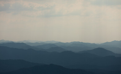 Ridge under the misty sky. Faint sunlight shining through the clouds.
