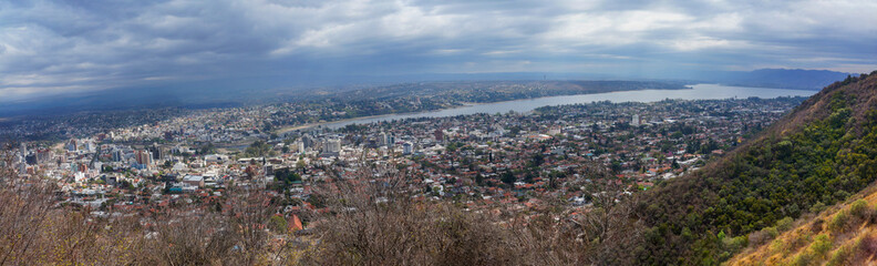 Fototapeta na wymiar Cityscape of Villa Carlos Paz, Cordoba. Taken from the top of a hill on a clouded sky morning 