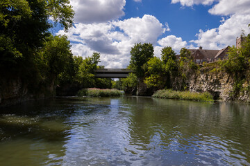 Bridge over the rapid Grand River, rocky banks, green trees, Fergus, Ontario, Canada