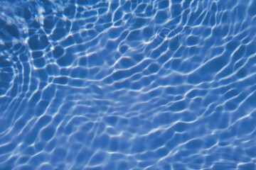 Fototapeta na wymiar Defocus blurred transparent blue colored clear calm water surface texture with splash, bubble. Shining blue water ripple background. Surface of water in swimming pool. Blue bubble water shining.