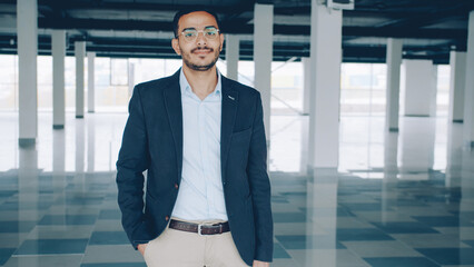portrait of Arab businessman standing indoors empty industrial building and looking at camera. Real estate deals and renting concept. - 536888666