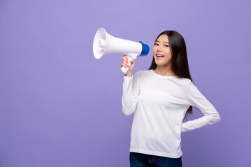 Young pretty Asian woman talking on magaphone isolated on purple color studio background with copy...