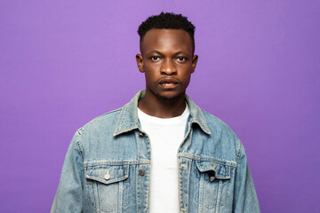 Obraz premium Portrait of young handsome African man face looking at camera in purple color studio isolated background