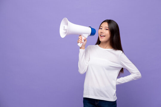 Young pretty Asian woman talking on magaphone isolated on purple color studio background with copy space