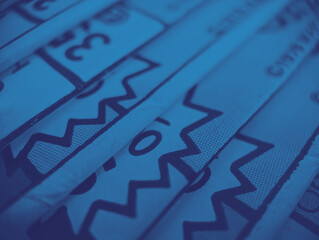 Old comic books stacked in a pile creates colorful background with abstract shapes and blue...