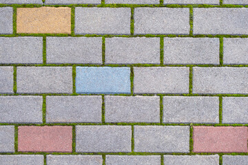 Cobblestone pavement Stone tile floor paving. Abstract background texture. Cobbles close-up with a green grass in the seams. Top view