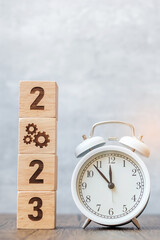 Happy New Year with vintage alarm clock and 2023 block with gear icon. New Start, Business Process, Team, teamwork, Goal, Target, Resolution, strategy, plan, Action and motivation concept