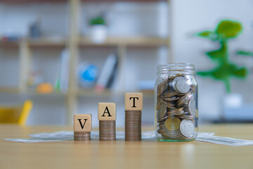 Vat Concept.Word vat with stacked coins and coins in a jar to collect money for paying VAT.