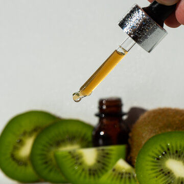 Kiwi butter. a skin and hair care product. Serum in a glass bottle with a pipette. Kiwi seed oil in a kiwi jar. The concept of aromatherapy, spa, beauty treatments and body care. Selective focus. 
