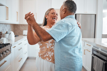Happy senior couple, dance and laughing in joyful happiness for relationship bonding in the kitchen...