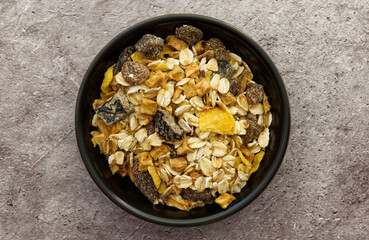 Bowl of muesli isolated on grey concrete background. Top down view. Healthy breakfast