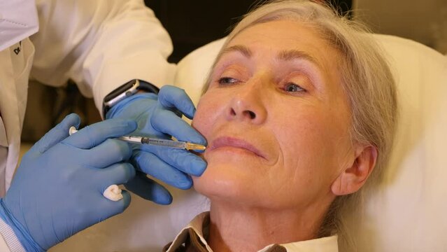 Senior woman recieving botulinotherapy during doctor's appointment in cosmetological clinic.