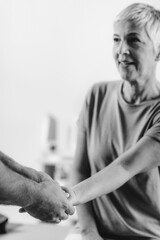 Therapist Checking Senior Woman’s Arm