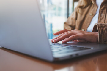 Closeup image of a woman working and touching on laptop computer touchpad