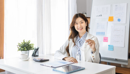 Obraz na płótnie Canvas Office worker with a beautiful Asian woman in a private office, Daily routine of office workers, Welcome to work in the morning with a bright smile, Businesswoman in office concept.