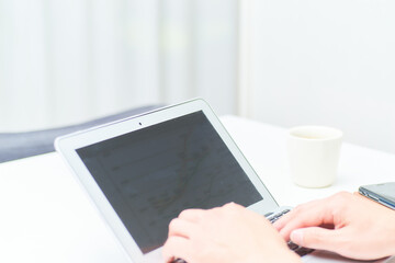 リモートでパソコンとスマホをいじる男性