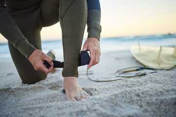 Foot, with surfboard and leash on sand prepare to enter sea, on beach and to relax on holiday,...