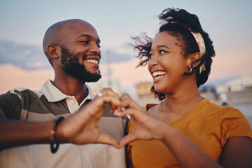 Black couple, heart hand and celebrate relationship being happy, smile and romantic outdoor...