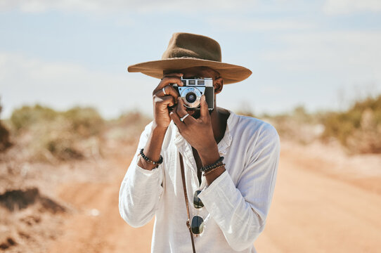 Travel, photographer and man in a desert in Australia, taking photograph of nature, beauty and earth. Countryside, photography and black man on discovery journey, traveling and enjoying the view
