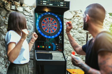 Young attractive couple playing darts