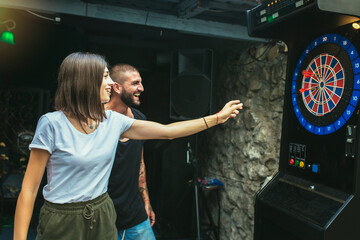 Young attractive couple playing darts