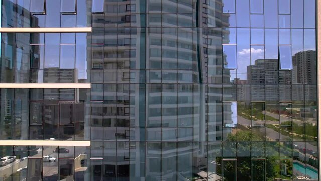 edificio con ventanas de espejo.  Vista desde dron ascendiendo desde la base