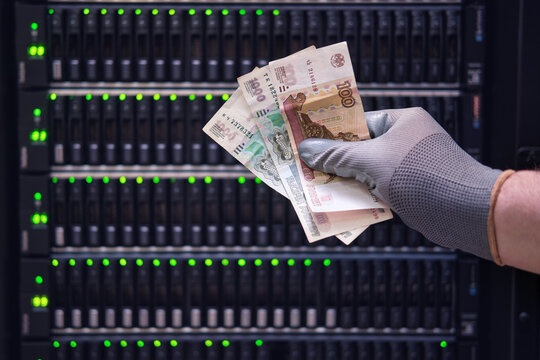 Money russian rubles in the hands of a man on the background of a data storage server, close-up