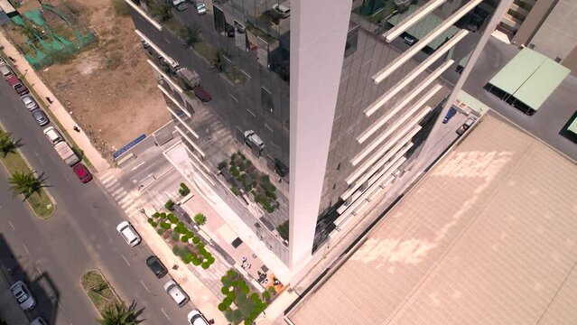 vista desde dron descendiendo por el costado de un edificio con ventanas de espejo