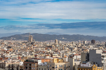 Fototapeta na wymiar Cityscape of Barcelona with blue sky and mountains on background. Vacation and travel concept 