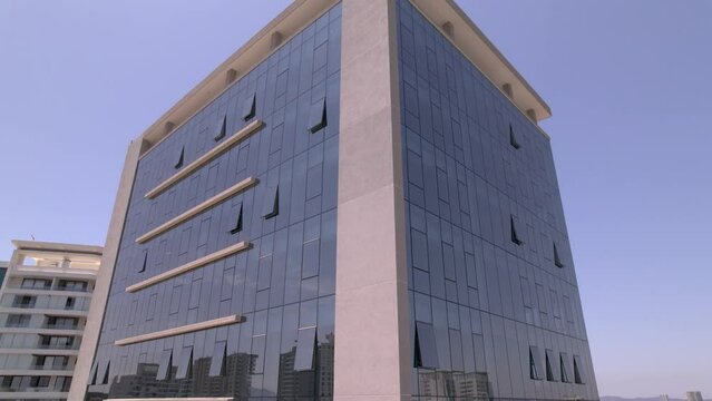 vista desde dron de un edificio de ventanas tipo espejo, elevandose desde la base hasta el techo