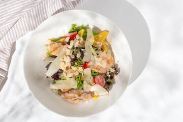 Classic caesar salad with grilled chicken fillet and parmesan cheese. top view