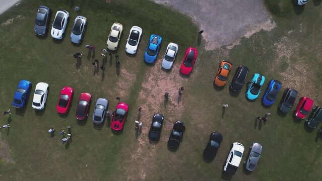 Rows Of Colorful Luxury UK Supercars At The Car Park Next To Flamborough Head Lighthouse In Flamborough Head, East Yorkshire, England. - Aerial Ascending, Rotating Shot