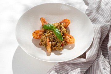 Orzo pasta with shrimps on white background for restaurant menu.