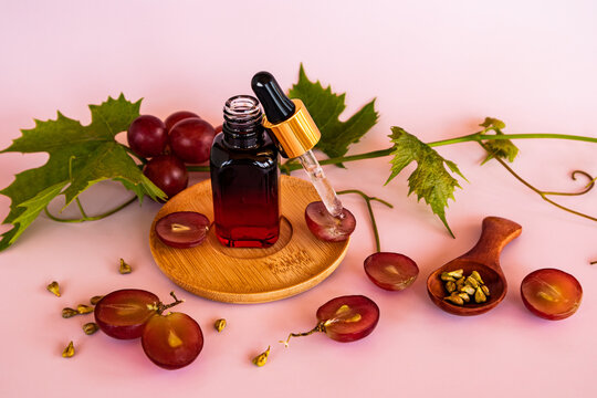 whey or grape seed oil in a colored bottle on a wooden plate with a pipette filled with cosmetics. natural skin care.