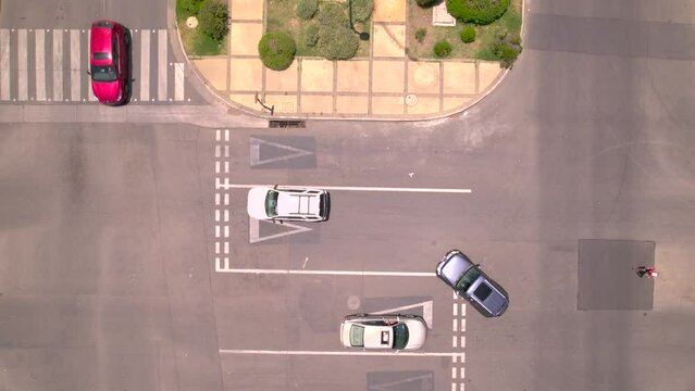 Vista aerea desde dron del trafico en una ciudad y una plaza con vegetacion verde y arboles