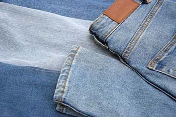 Lots of jeans pants in a stack. Denim background.