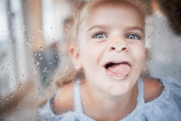 Funny, kid and tongue on window portrait with goofy and enthusiastic face pressed on surface....