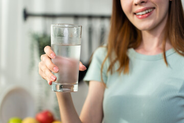 Close up of Caucasian woman drink a glass of water in kitchen at home. 