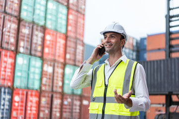 Handsome Caucasian businessman use phone to work in container terminal. 