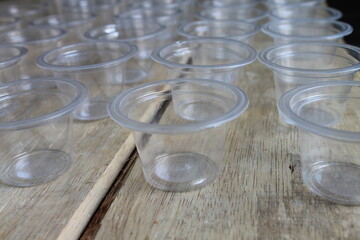 Rows of empty plastic cups on a wooden table