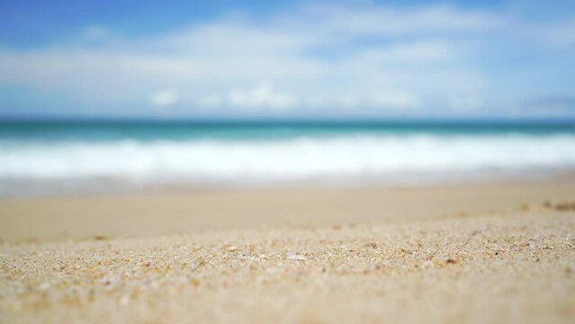 Close-up sand beach with waves.  Beach blurred sky island background.