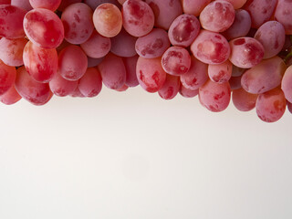 Ripe red grapes. Pink bunch with leaves isolated on white. With trajectory cropping. Full depth of...