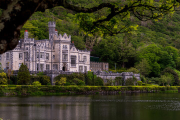 Fototapeta na wymiar Kylemore Abbey, beautiful castle like abbey reflected in lake at the foot of a mountain. Benedictine monastery founded in 1920, in Connemara, Ireland