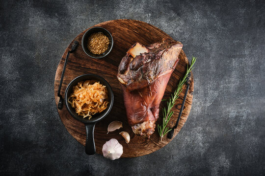 Smoked pork knuckle with stewed cabbage and spices. Baked Eisbein. Smoked ham hock.