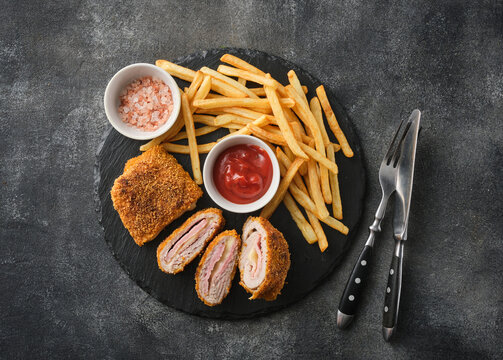 Fried chicken Cordon bleu with cheese and ham in breadcrumbs with french fries.