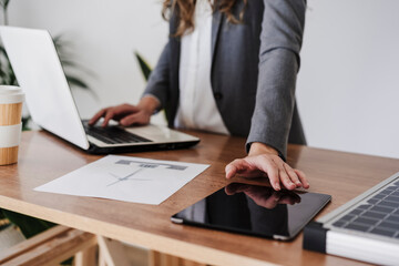 Young female engineer working in her modern office using digital tablet. close up