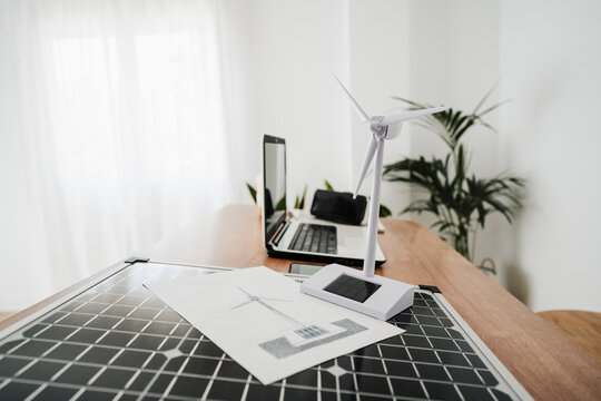Portable solar panel and windturbine model on engineer's desk