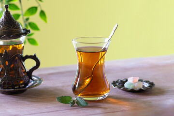 Traditional turkish tea in a glass next to turkish delight.