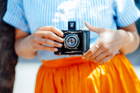 Woman holding vintage analog camera on sunny day