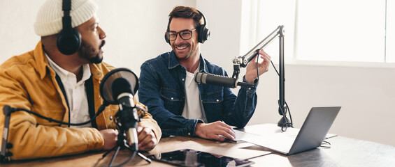 Happy radio presenter interviewing a guest on a podcast